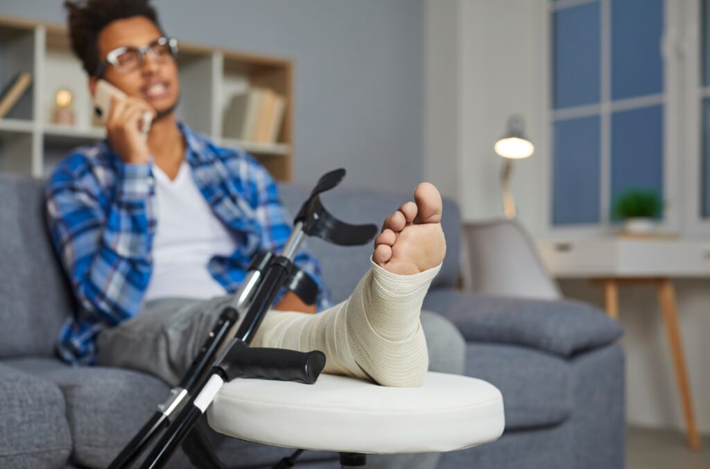 Person with a bandaged foot resting on a cushion | medical malpractice lawyer​ | Menzer Law|A woman focused