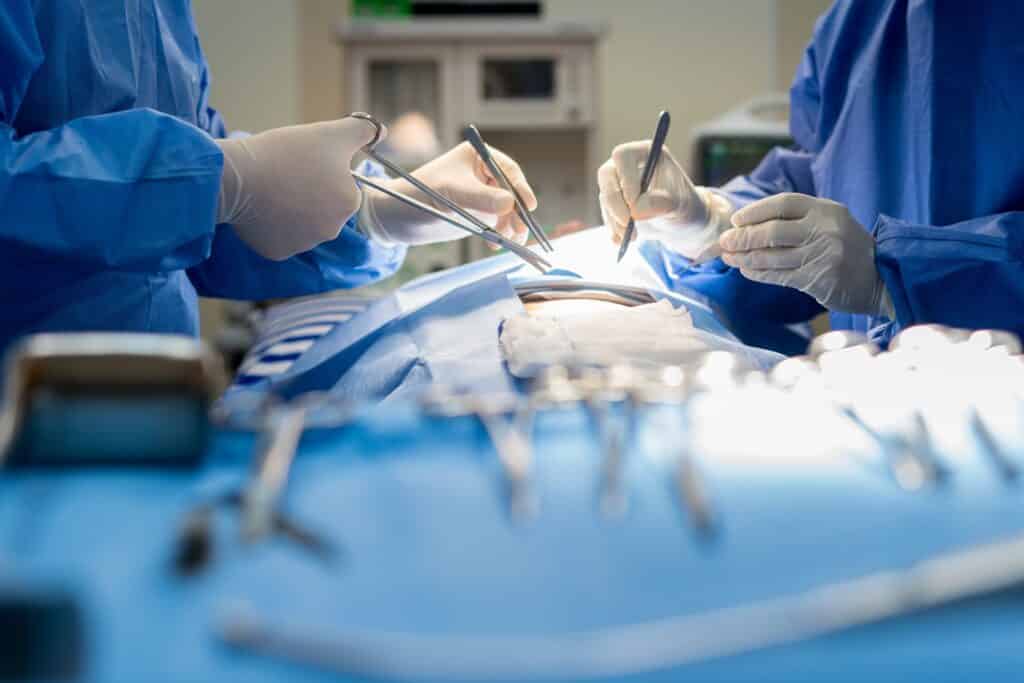 Two surgeons work on a patient in a hospital.